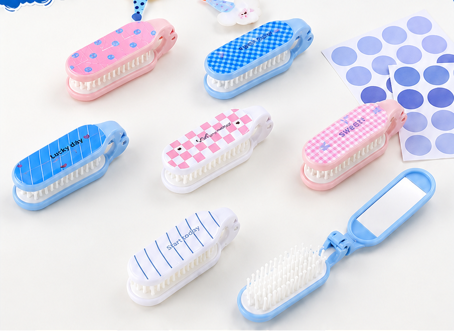 A product catalog graphic for a set of folding mirror hairbrushes. The top half shows several pastel-colored brush-and-mirror combos in pink, blue, and white, with a blue hair-tie sample.
